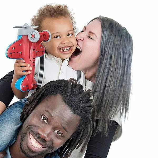 Parents laughing with their young child during a family photo shoot