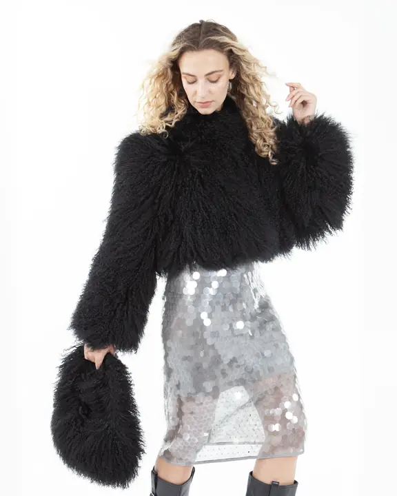 Fashion model in a black shearling jacket and silver sequin skirt