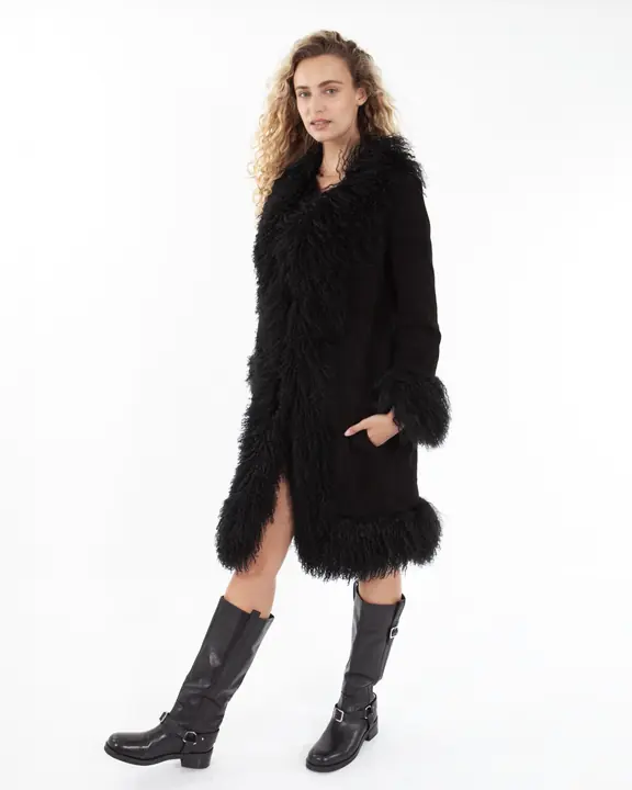 Full-length fashion model in a black shearling coat and leather boots