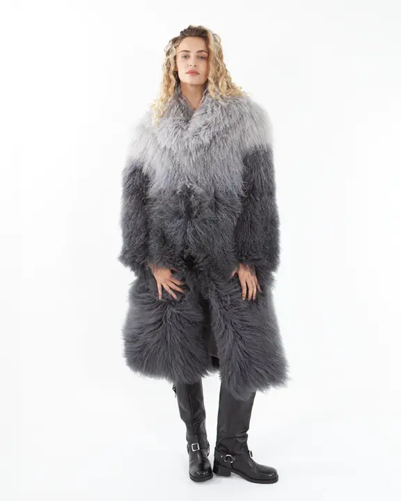 Full-length editorial portrait in a long grey shearling coat