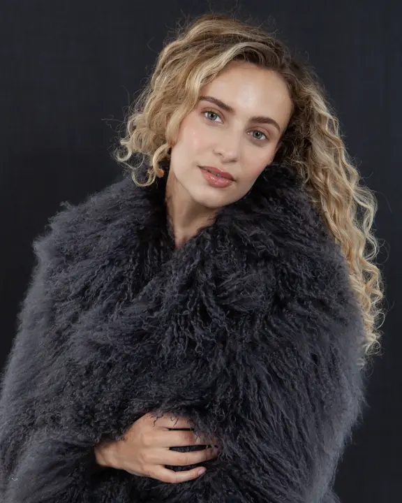 Beauty portrait of a model in grey shearling against a dark background